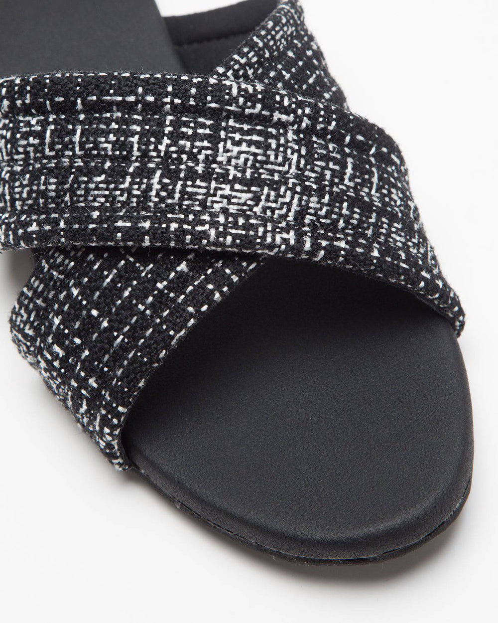 Black cross-strapped jute flats by Windlust, showcasing their stylish and comfortable design with woven jute material.