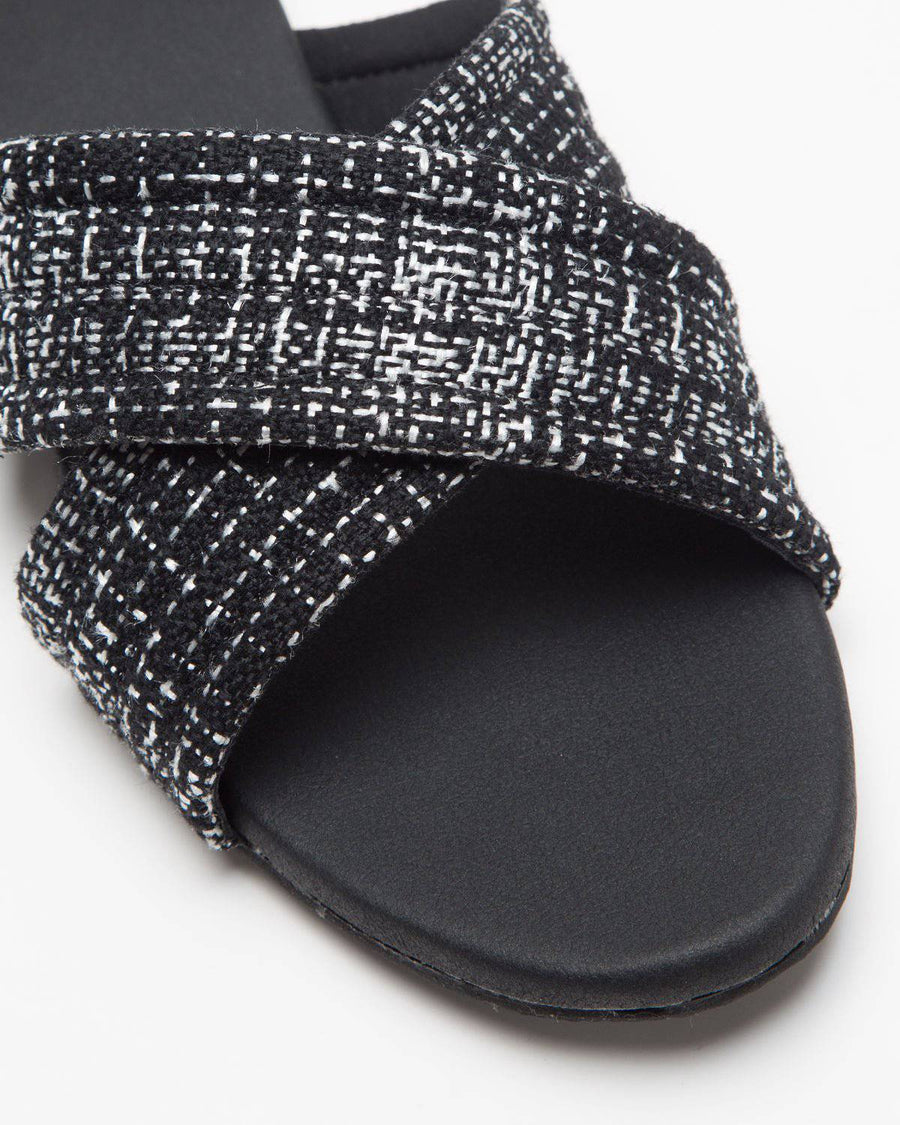 Black cross-strapped jute flats by Windlust, showcasing their stylish and comfortable design with woven jute material.