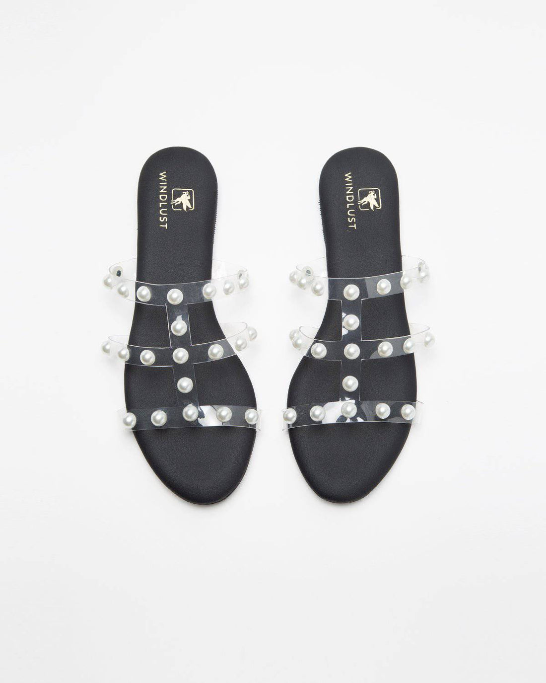 Black flats with three straps and pearl embellishments by Windlust, showcasing elegant and stylish footwear design.