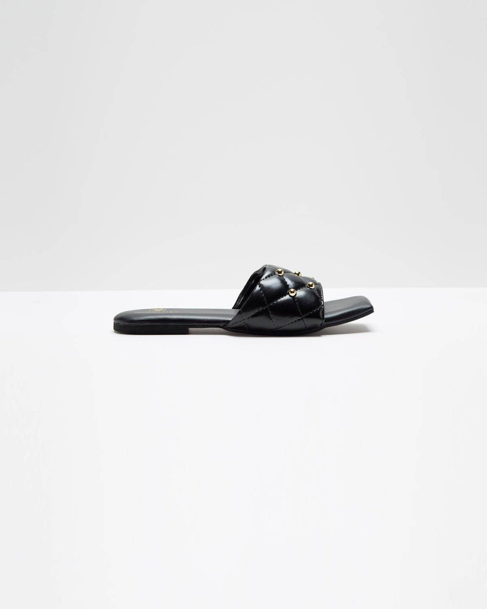 Black Windlust T-shaped flats with studded accents, featuring a sleek design and comfortable flat sole for everyday wear.