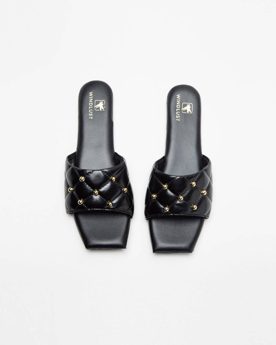 Black studded T-shaped flats by Windlust, featuring pointed toe and studded detailing, stylish footwear for casual or dressy wear.