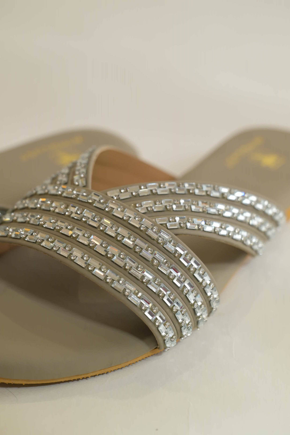 Warm grey Windlust flats with triple straps and Swarovski stone embellishments, showcasing elegant, comfortable footwear.