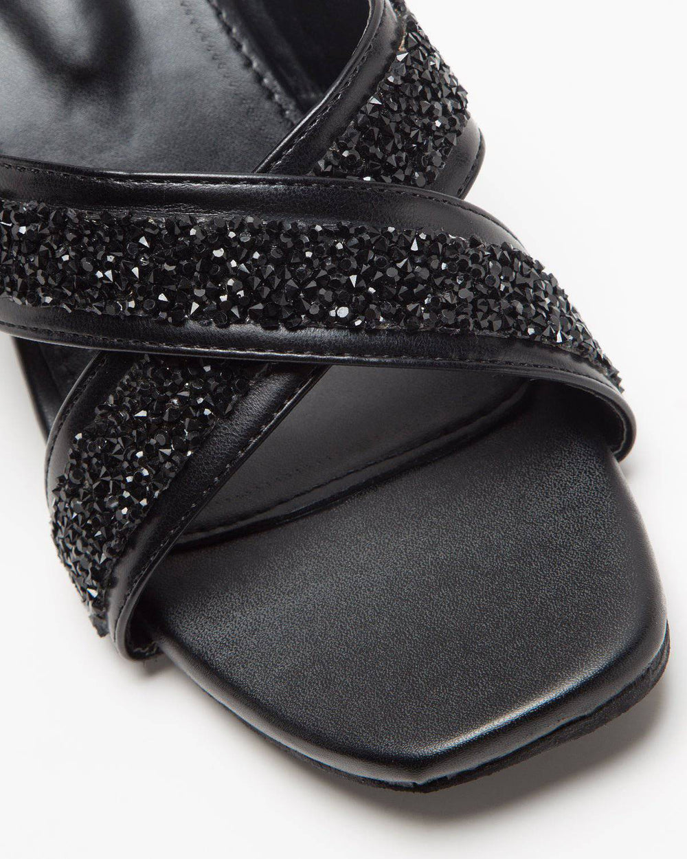 Black Windlust cross-strapped embellished lace-up heels showing detailed straps and decorative embellishments on a sleek shoe.