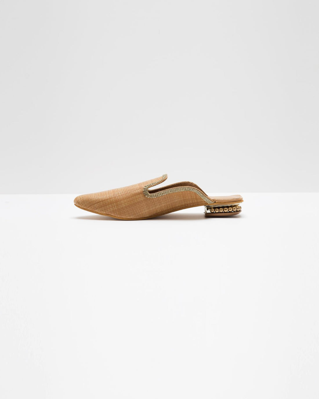 Fine textured beige mules by Windlust with a sleek design, showcasing the comfortable slip-on style and subtle detailing.
