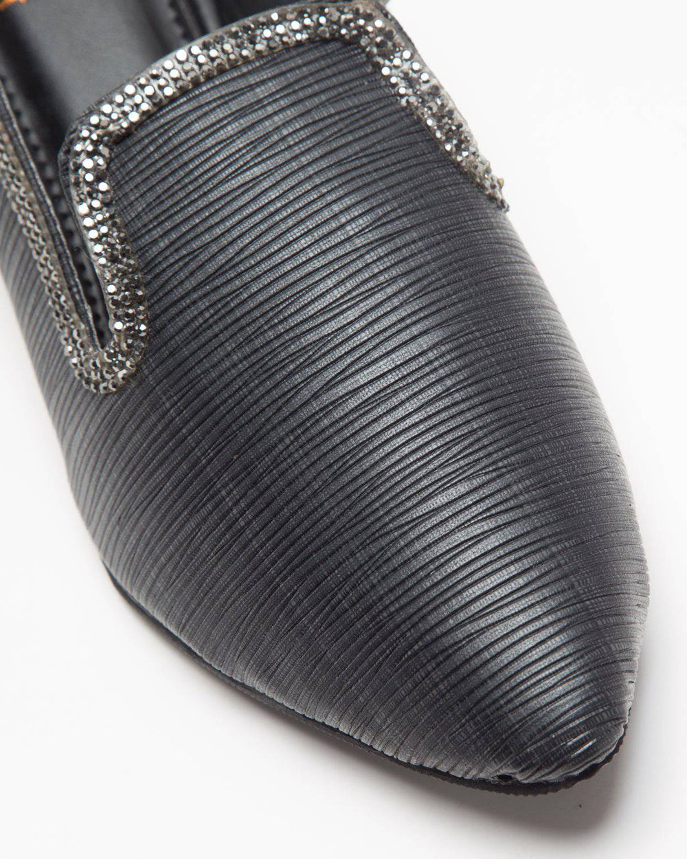 Black textured mules by Windlust, stylish slip-on shoes with fine detailing, shown from a side view.
